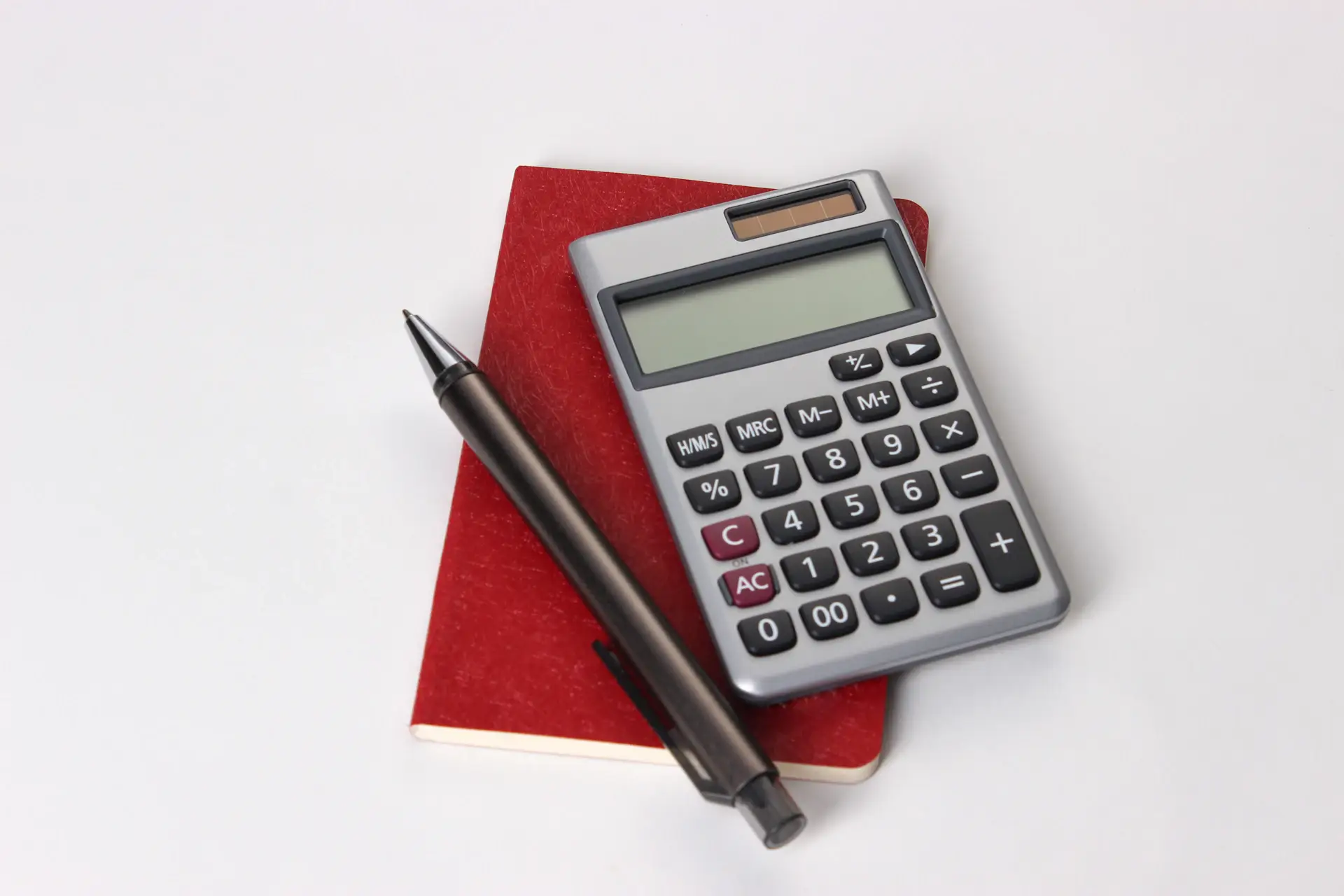 Calculatrice et stylo posés sur un carnet