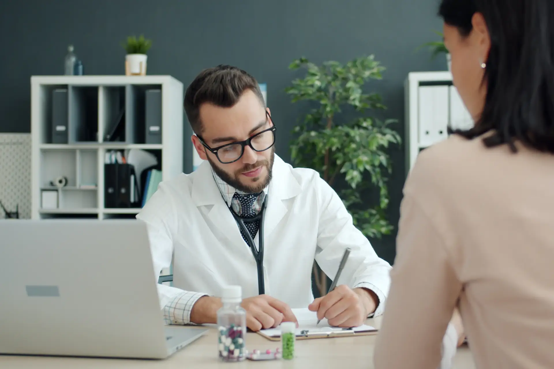 Médecin prenant des notes face à une patiente